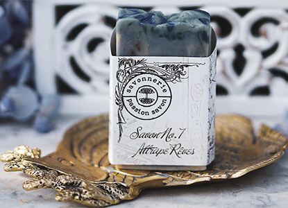 Photo d'un savon bleu sur un porte savon doré.