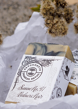 Photo d'un savon artisanal sur un papier de soie avec des fleurs séchées.