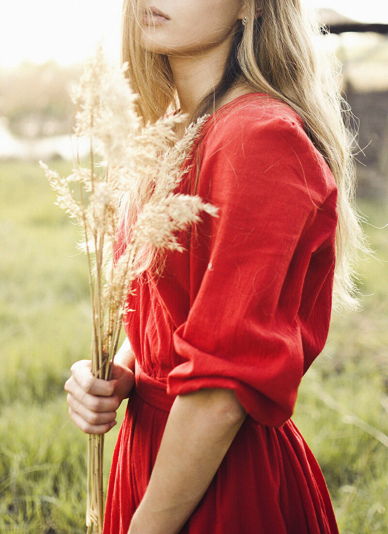 Photo d'une femme dans un champ avec un bouquet de pampas.